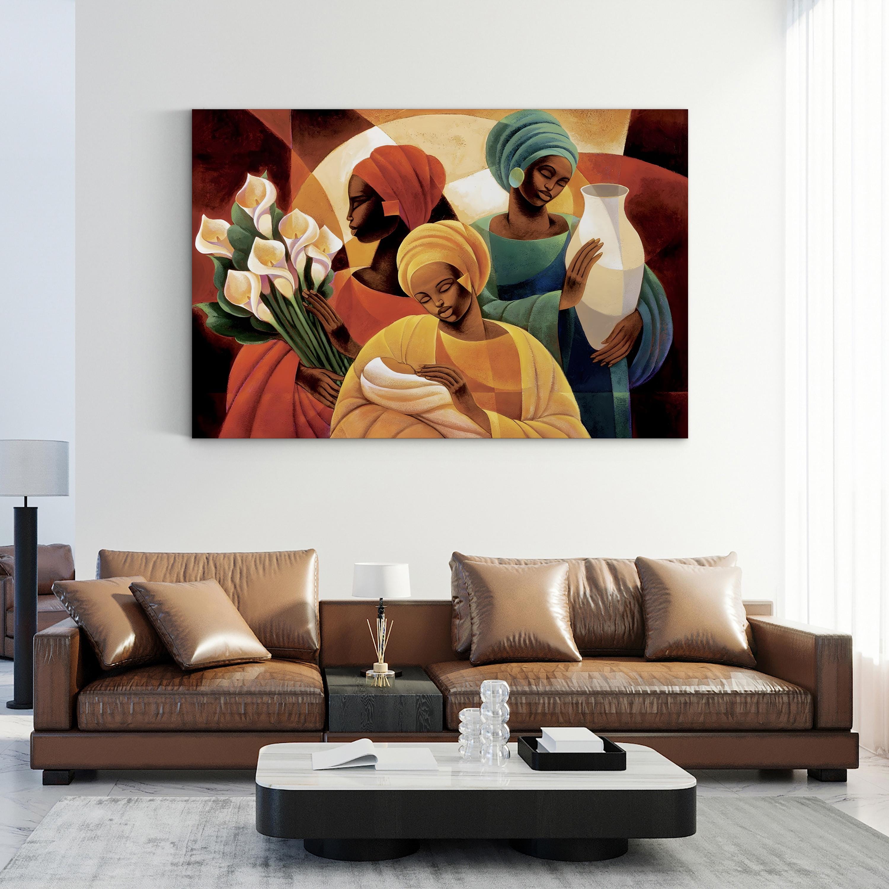 Living room with a painting of three women on the wall above a brown leather sofa.