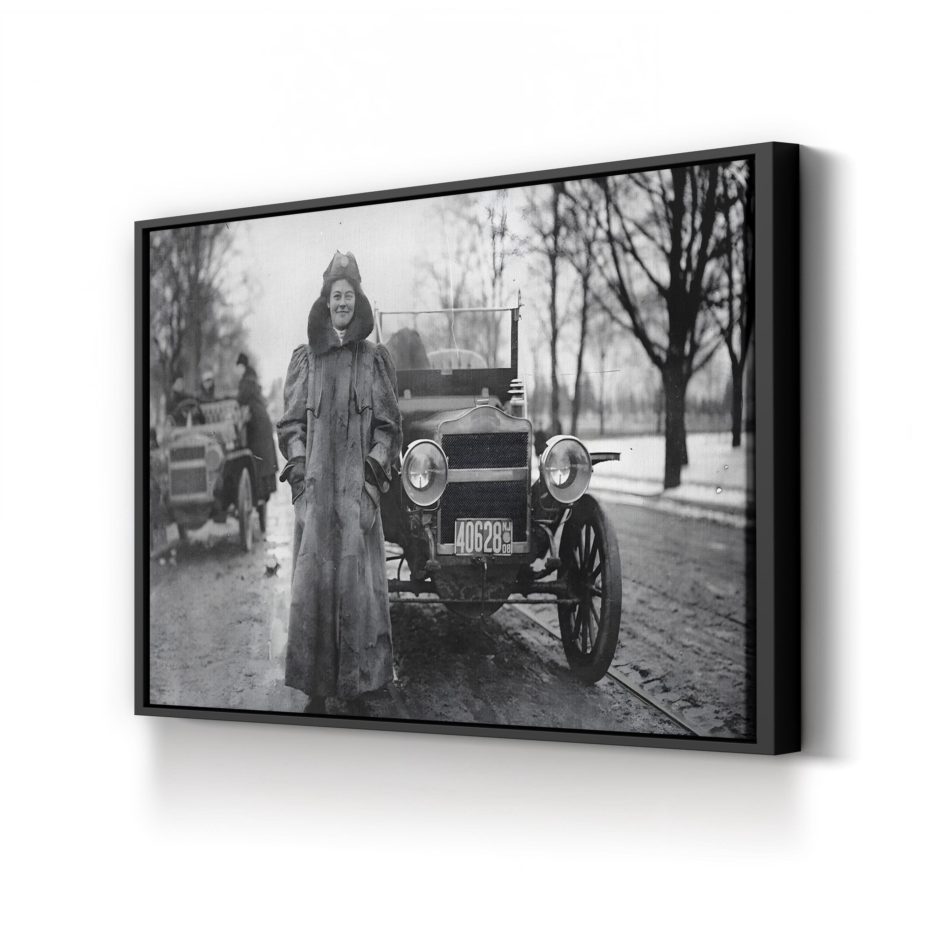 Vintage black and white photo of a woman standing next to an old car on a snowy street.