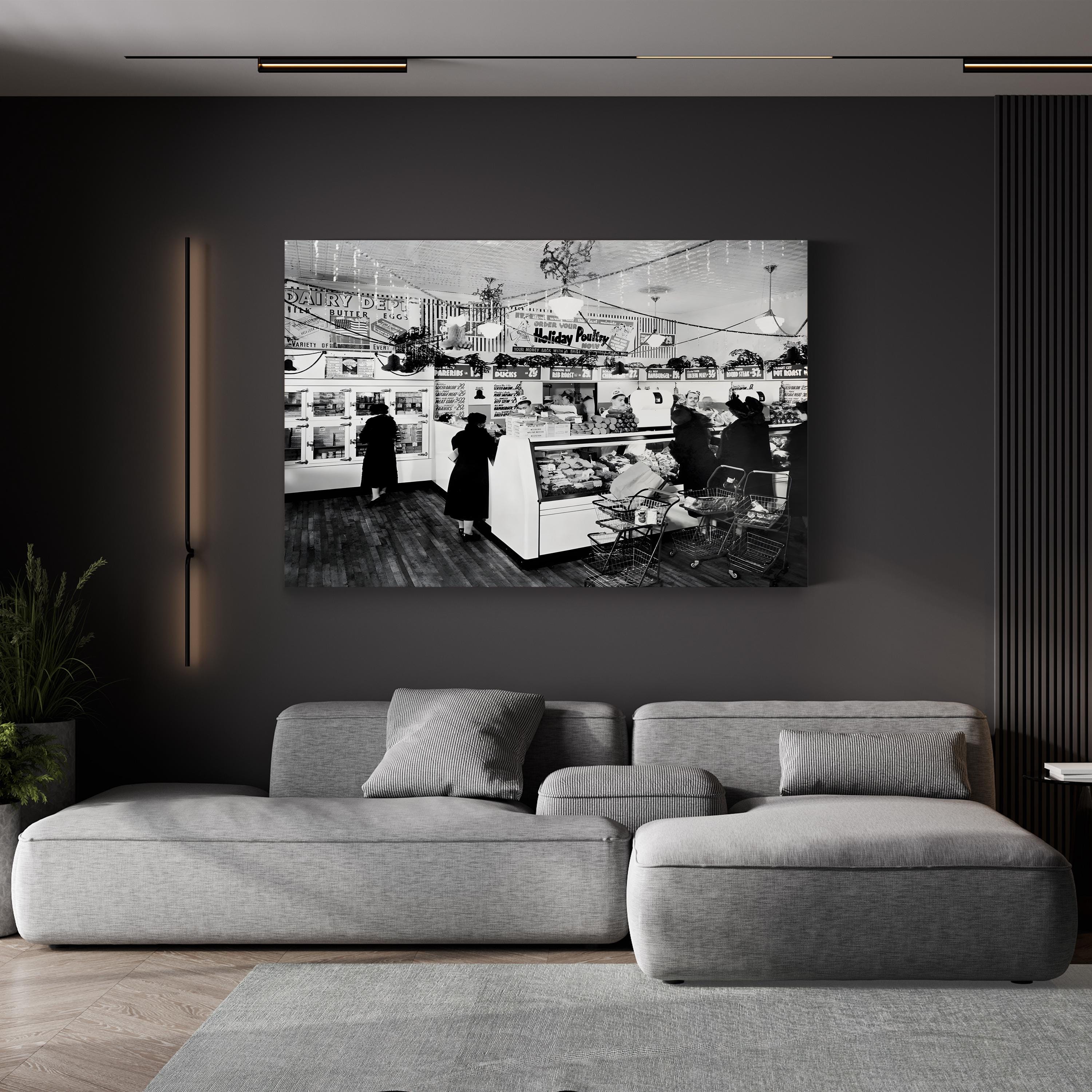 American Grocery Deli, 1938 canvas print in a black frame displayed above a gray sofa