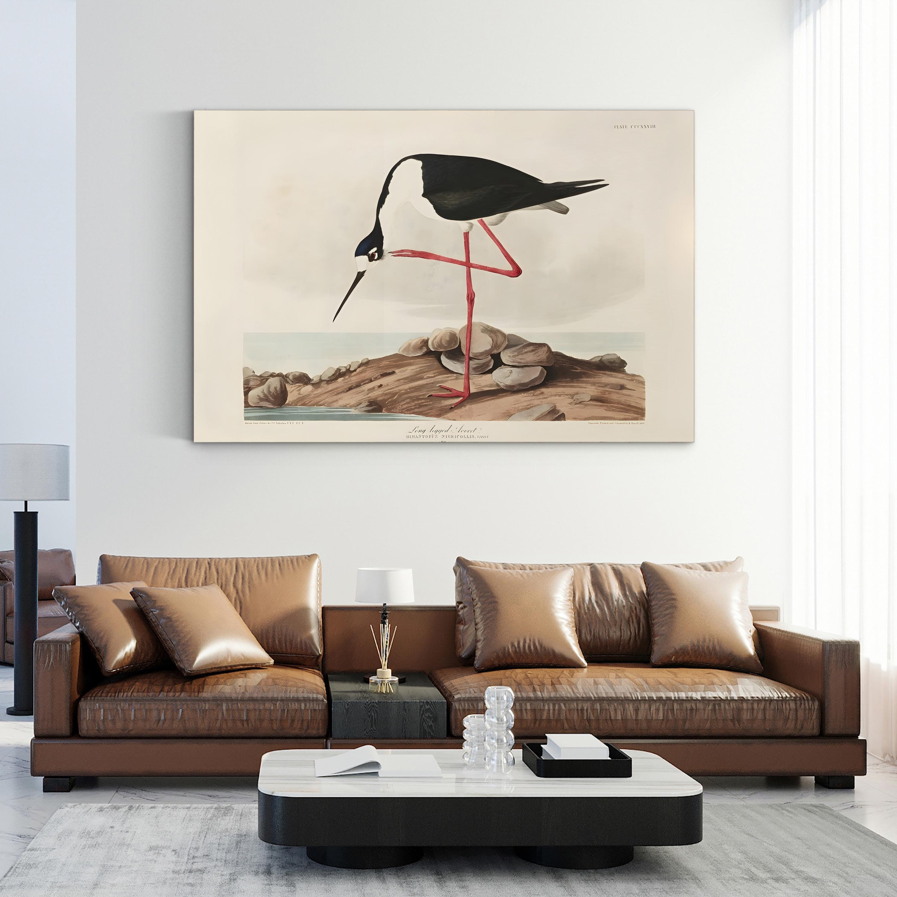 Modern living room with a brown leather sofa and a decorative painting of a long-legged avocet bird on the wall.