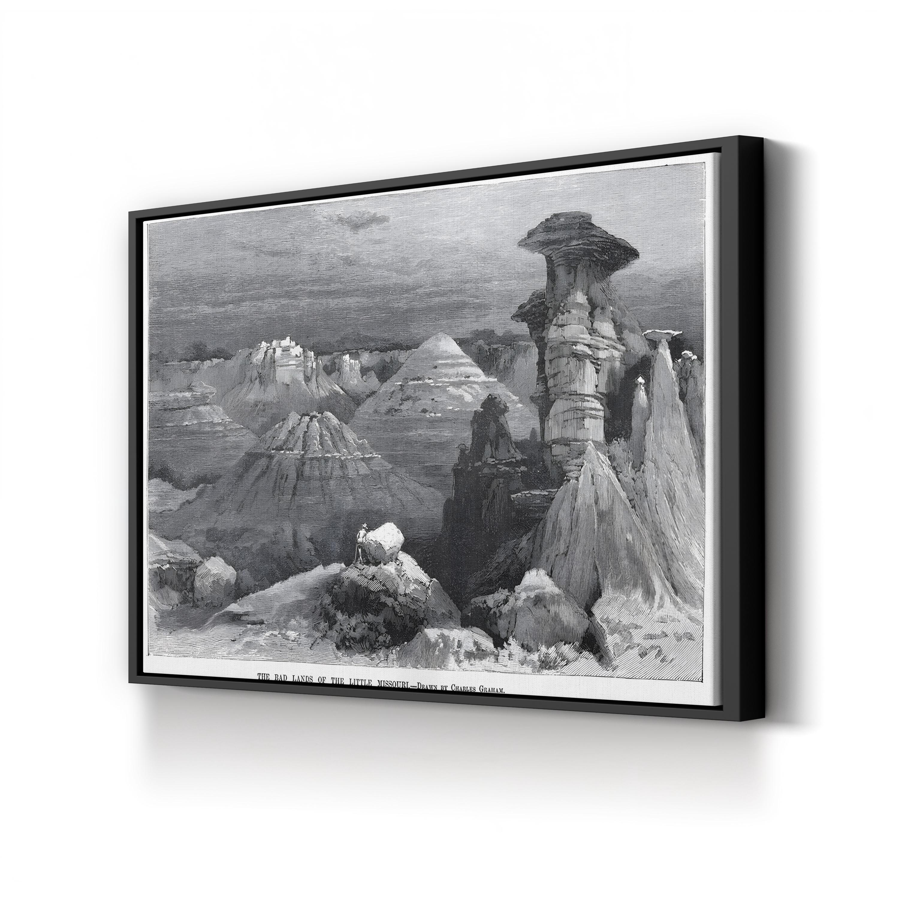 Framed black and white landscape print of a desert scene with rock formations.