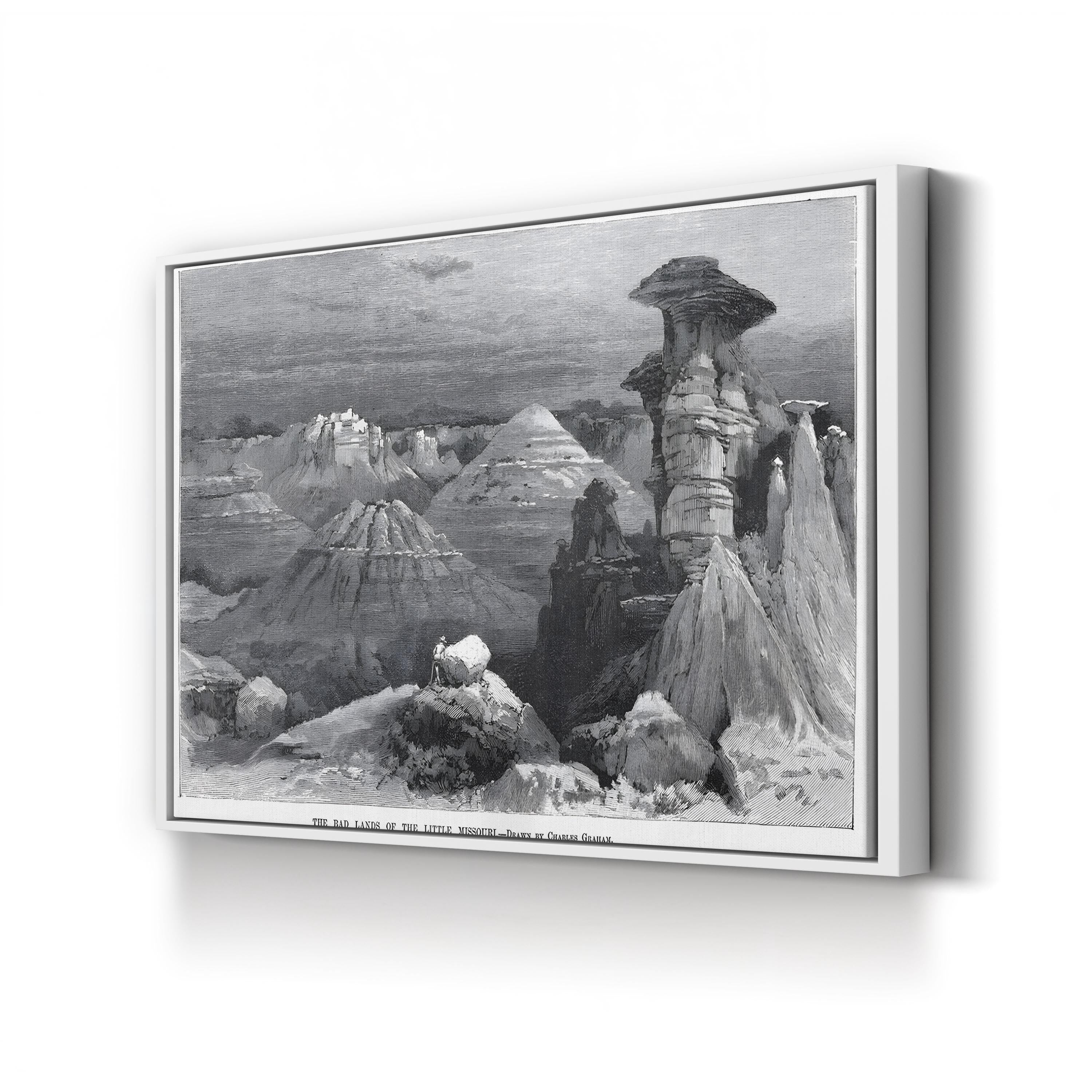 Framed black and white landscape print of a desert scene with rock formations.