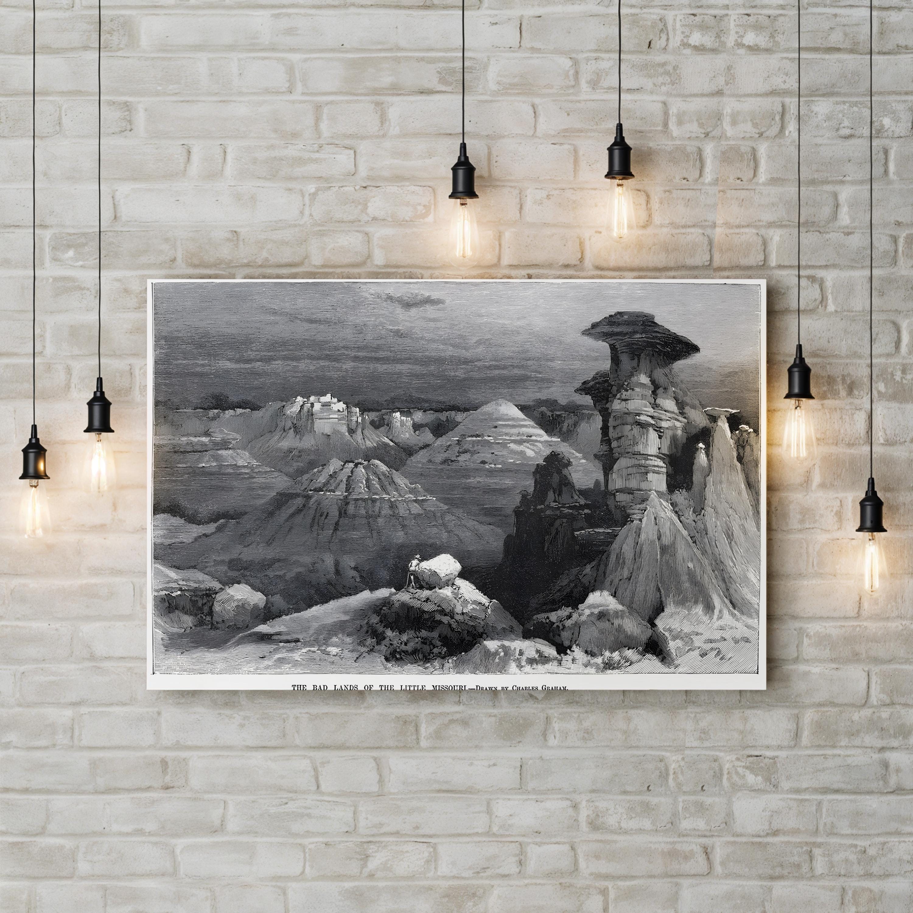 Framed black and white landscape print on a brick wall with pendant lights.