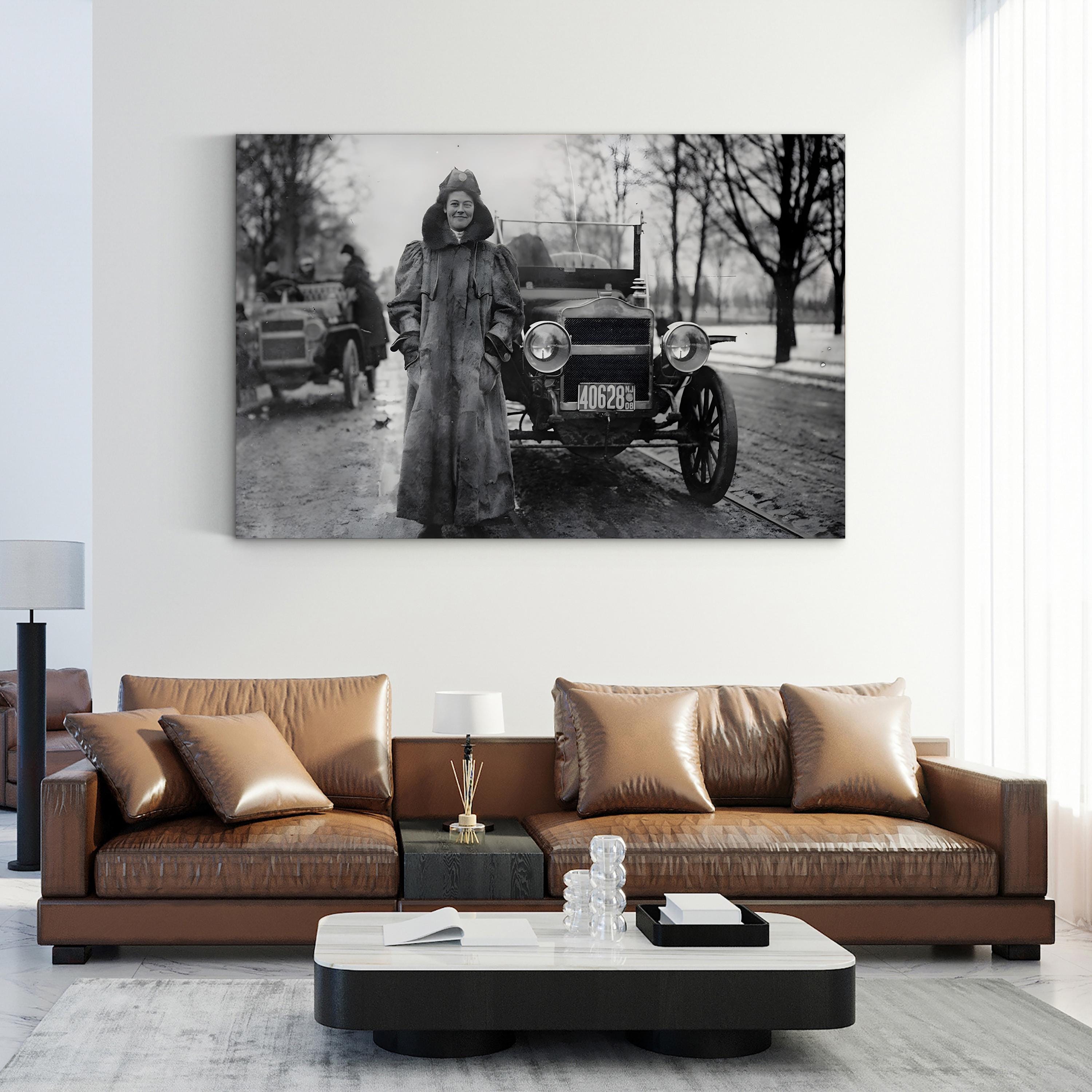 Living room with a brown leather sofa and a large black and white photo of a woman and car on the wall.
