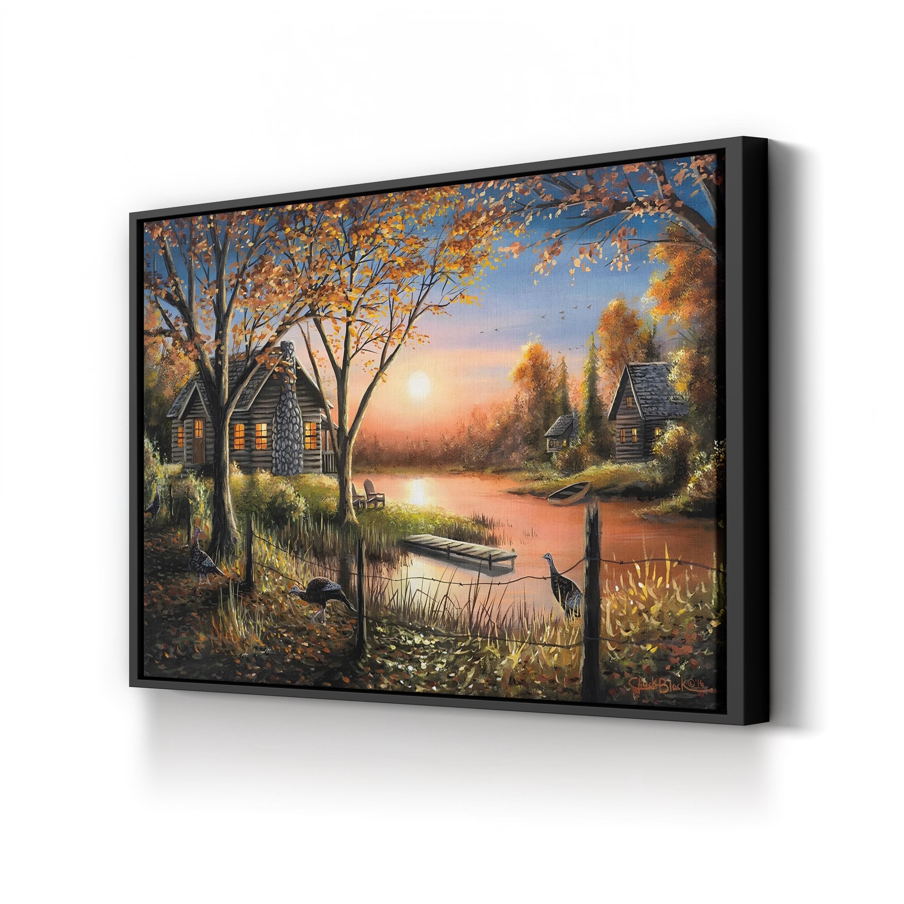 Framed artwork of a serene landscape with a cabin by a lake at sunset.